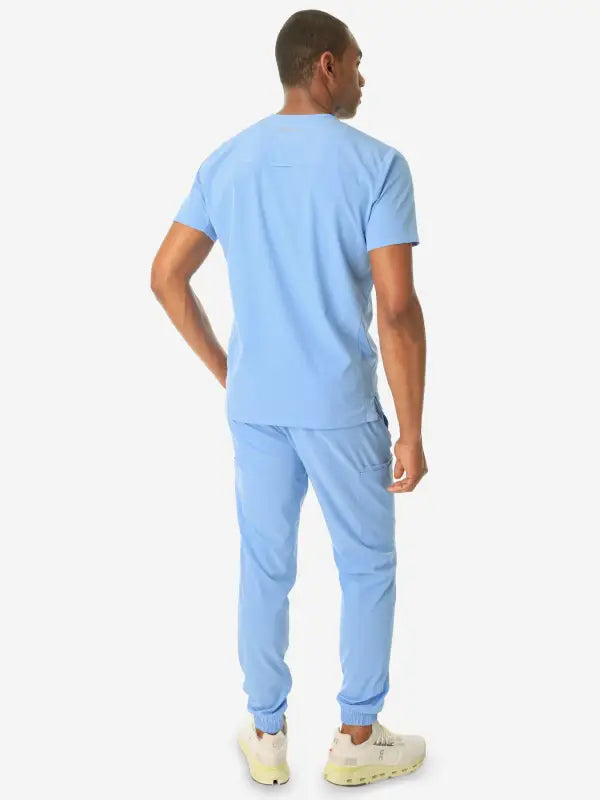 Light blue men’s double-pocket scrub top with short sleeves and jogger-style pants