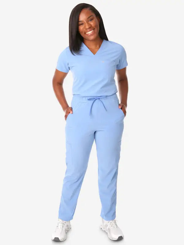 Light blue women’s tuckable one-pocket scrub top with matching pants for medical professionals