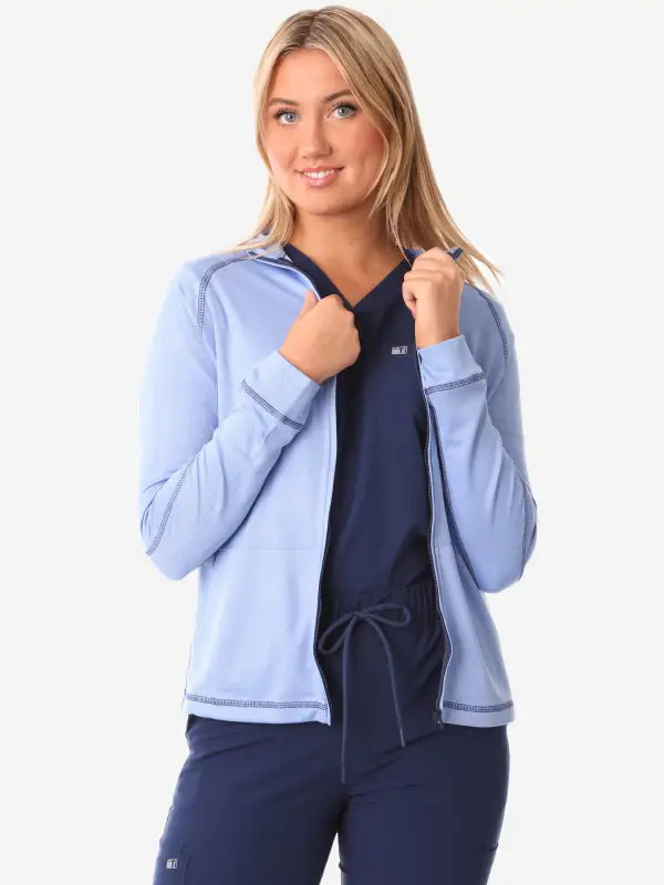 Light blue women’s scrub jacket with navy blue trim for athletic comfort