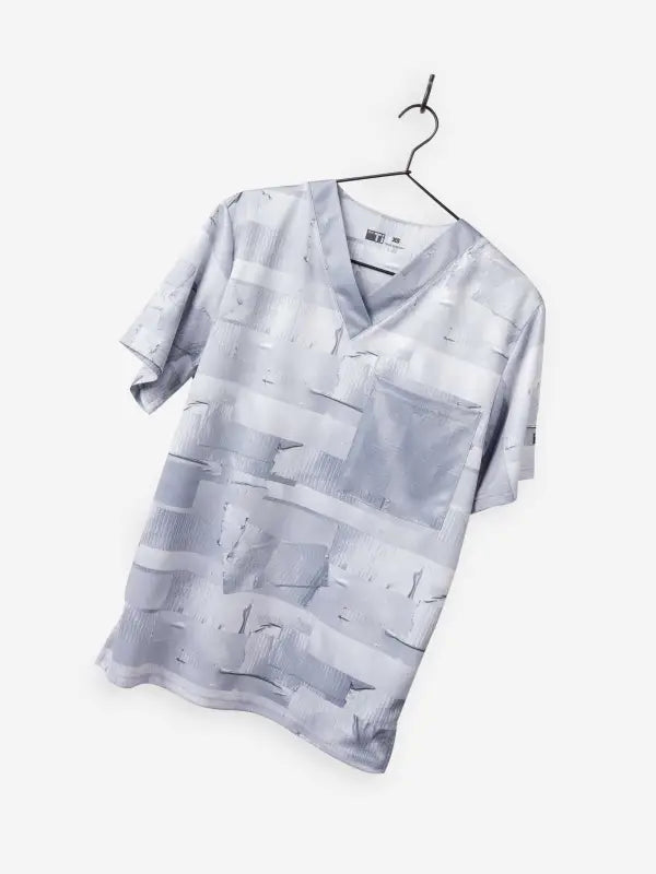 Light gray men’s duct tape scrub top with abstract geometric pattern on hanger