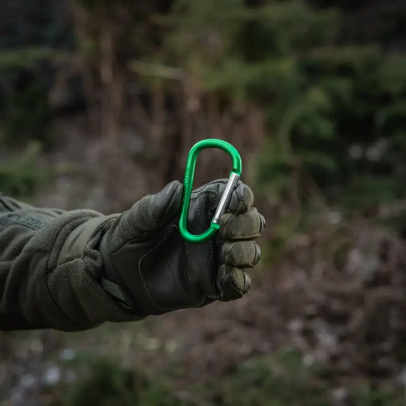 Gloved hand holding an M-Tac Carabiner, ideal for first responders and firefighters