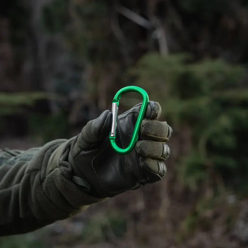 Bright green M-Tac carabiner held by a gloved hand, ideal for first responders and firefighters