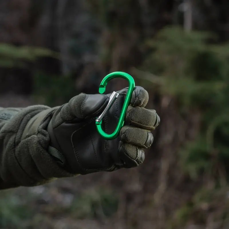 Bright green M-Tac Carabiner held by a gloved hand, ideal for first responders and firefighters