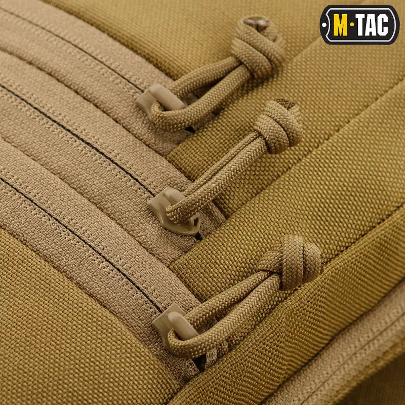 Tan tactical backpack strap with cord lacing on M-Tac Concealed Carry Sling Bag Elite Gen.IV