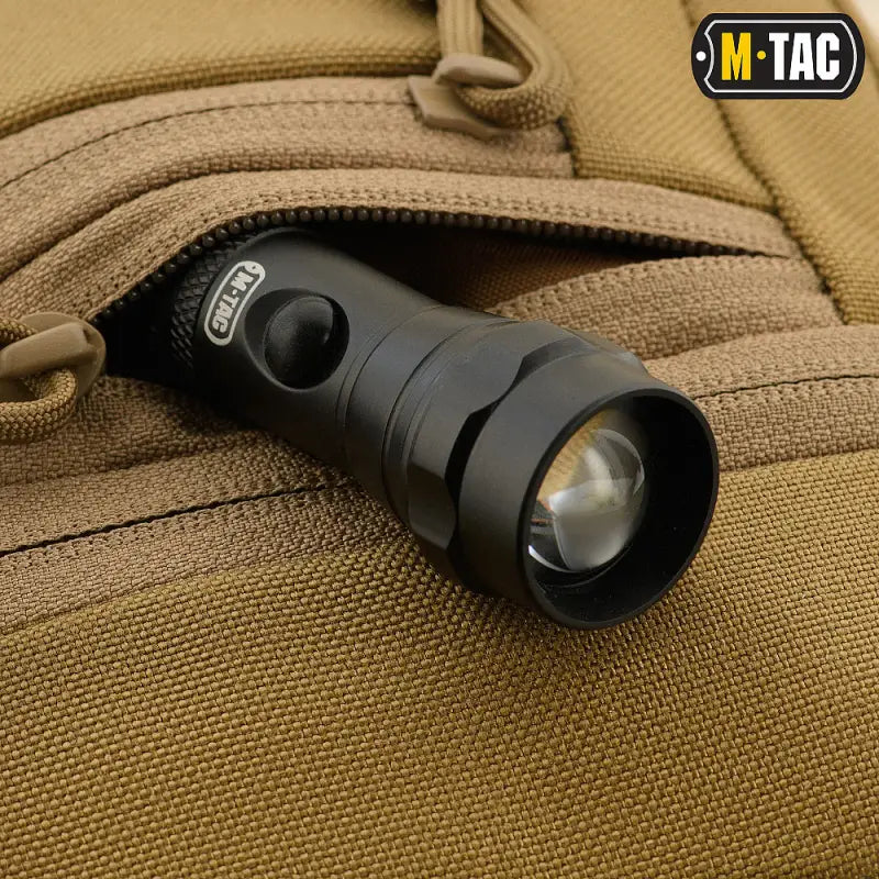 Black tactical flashlight with adjustable beam in M-Tac Concealed Carry Sling Bag Elite Gen.IV