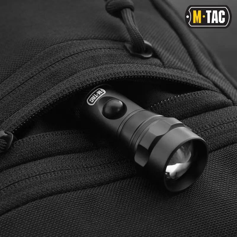 Black tactical flashlight with adjustable beam in M-Tac Concealed Carry Sling Bag Elite Gen.IV