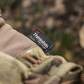 Black Thinsulate label on M-Tac Gloves Fleece Thinsulate with camo fabric background