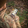 Smartphone with app held by person in camouflage wearing M-Tac Gloves Fleece Thinsulate