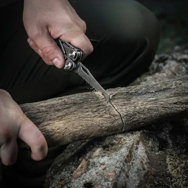 M-Tac Multitool Type 3 Grey cutting a wooden log with a folding pocket knife