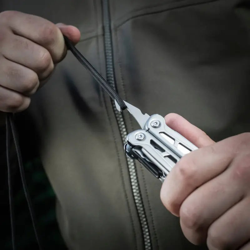 Stainless steel M-Tac Multitool Type 3 Grey being used to fix a zipper