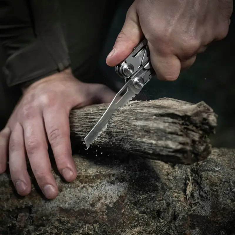 Hands using M-Tac Multitool Type 3 Grey to cut weathered wood with pruning shears