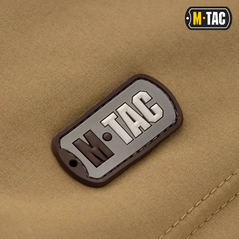 M-Tac logo patch in gray and black on M-Tac Soft Shell Jacket with two shoulder pockets