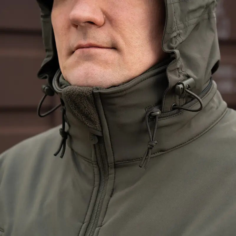 Olive green M-Tac Soft Shell Jacket with drawstring, high collar, and two shoulder pockets