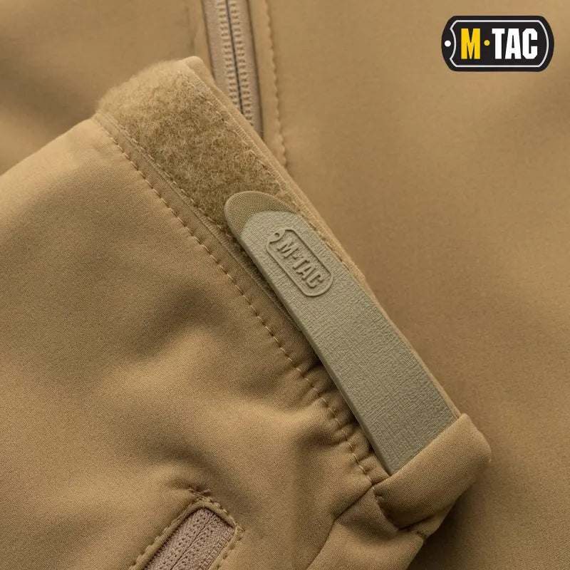 Tan sleeve of M-Tac Soft Shell Jacket showing logo patch and two shoulder pockets