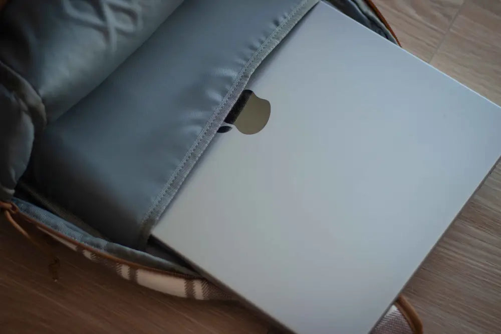 MacBook in gray sleeve inside ECHO EDC Backpack for concealed carry and protection