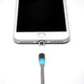 Magnetic USB charging cable with glowing blue tip near iPhone charging port and nylon cord
