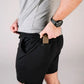 Man in black athletic shorts showcasing Carrier Shorts Mk.II for concealed carry