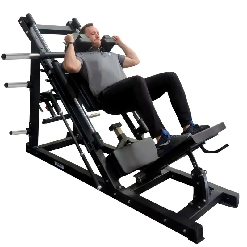 Man using a black plate loaded leg press hack squat combo machine for strength training