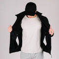Man in black tactical jacket Bravo with hand pocket showcasing durable tactical jacket style