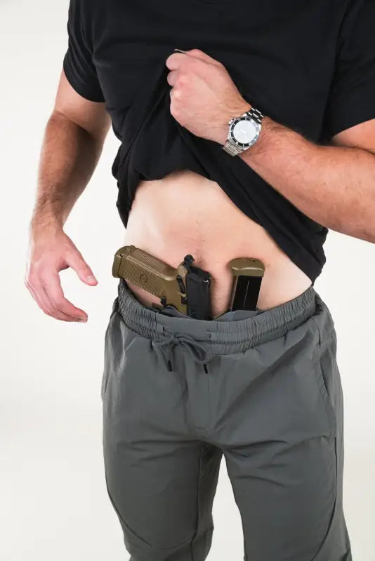 Man showcasing concealed carry with Carrier Traveler Joggers - Iron Grey and retention waistband