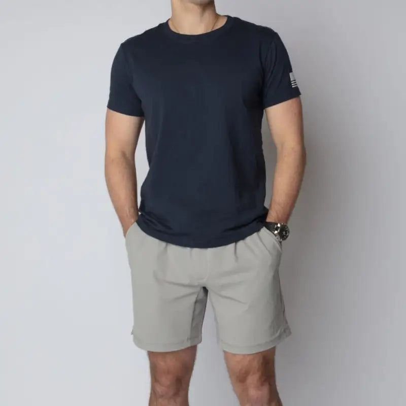 Man wearing dark blue t-shirt and khaki shorts from Arrowhead Tactical Apparel Carrier Shorts Mk.II