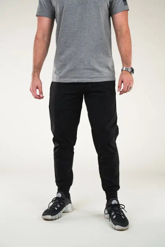 Man in gray t-shirt and black joggers featuring Carrier Traveler Joggers with concealed carry