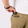 Man placing a gun in pocket wearing Carrier Shorts Mk.II for concealed carry, Arrowhead Tactical Apparel
