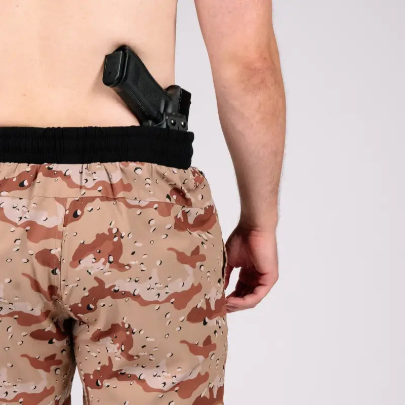Man with gun tucked into waistband wearing Carrier Training Shorts 5-inch inseam for concealed carry