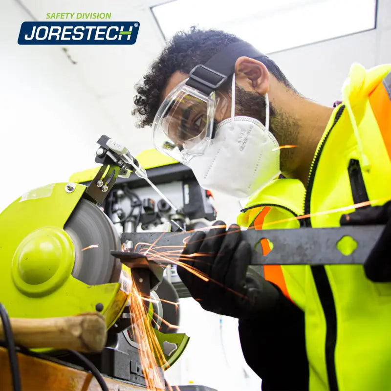 Man grinding metal while wearing anti-fog ventilated safety goggles for protection