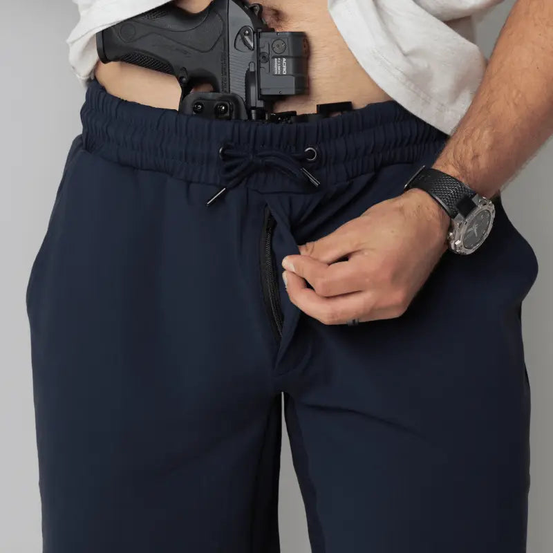 Man wearing navy carrier shorts with concealed carry functionality from Arrowhead Tactical Apparel