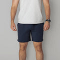 Man wearing navy Carrier Shorts Mk.II with 7-inch inseam from Arrowhead Tactical Apparel