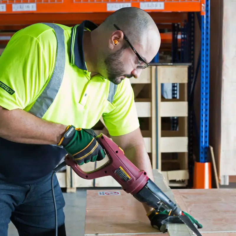 Man using a power saw while wearing 32dB NRR soft foam earplugs for noise reduction