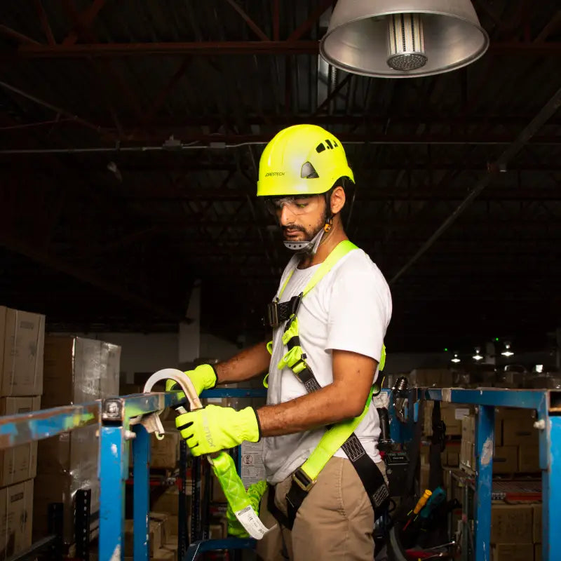 Man wearing hard hat and safety body harness for fall protection safety ANSI Z359 compliant