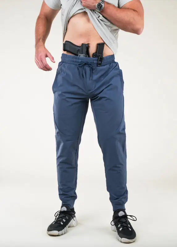 Man with two guns in waistband wearing Carrier Traveler Joggers - Steel Blue for concealed carry