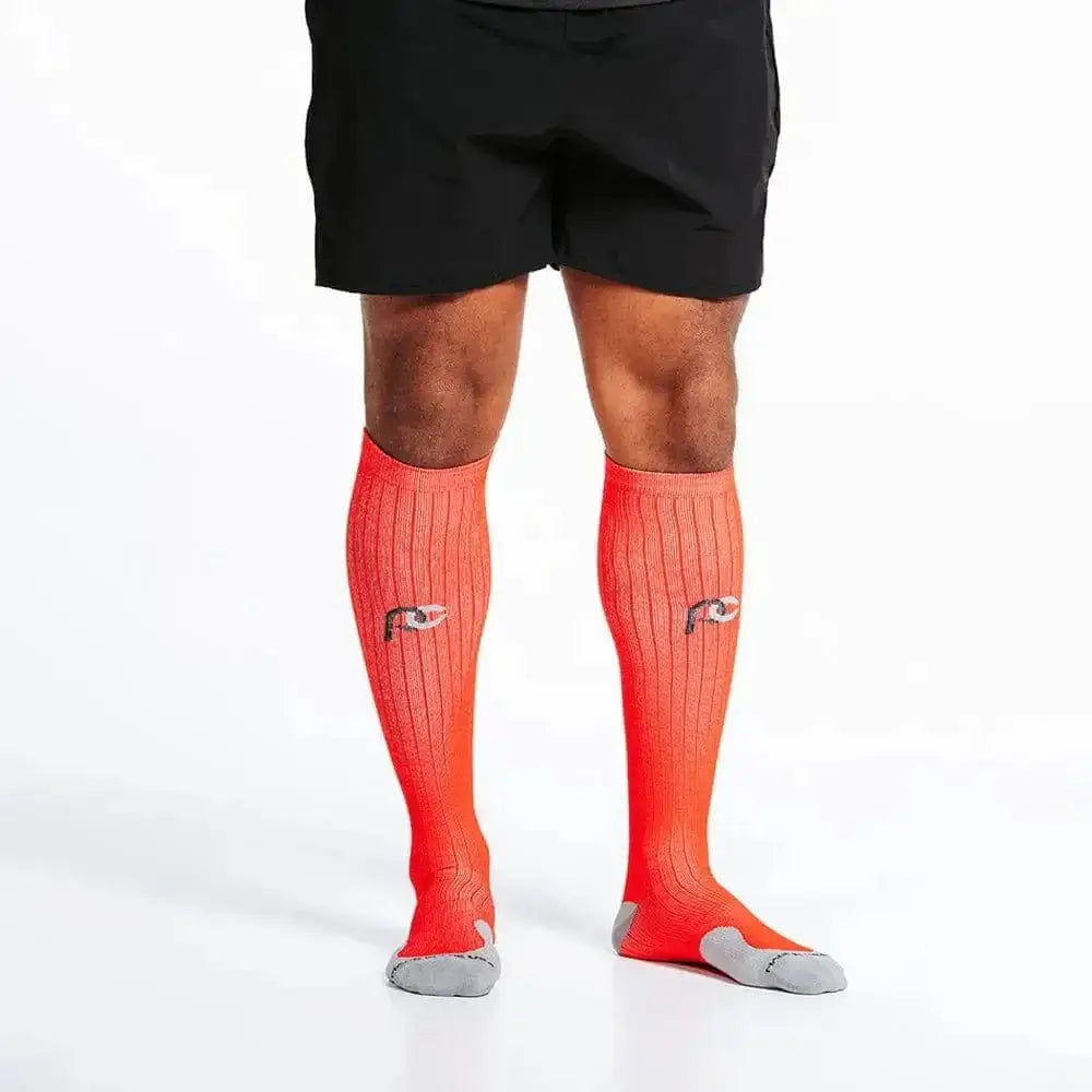 Bright coral knee-high compression socks with grey soles for marathon runners in red