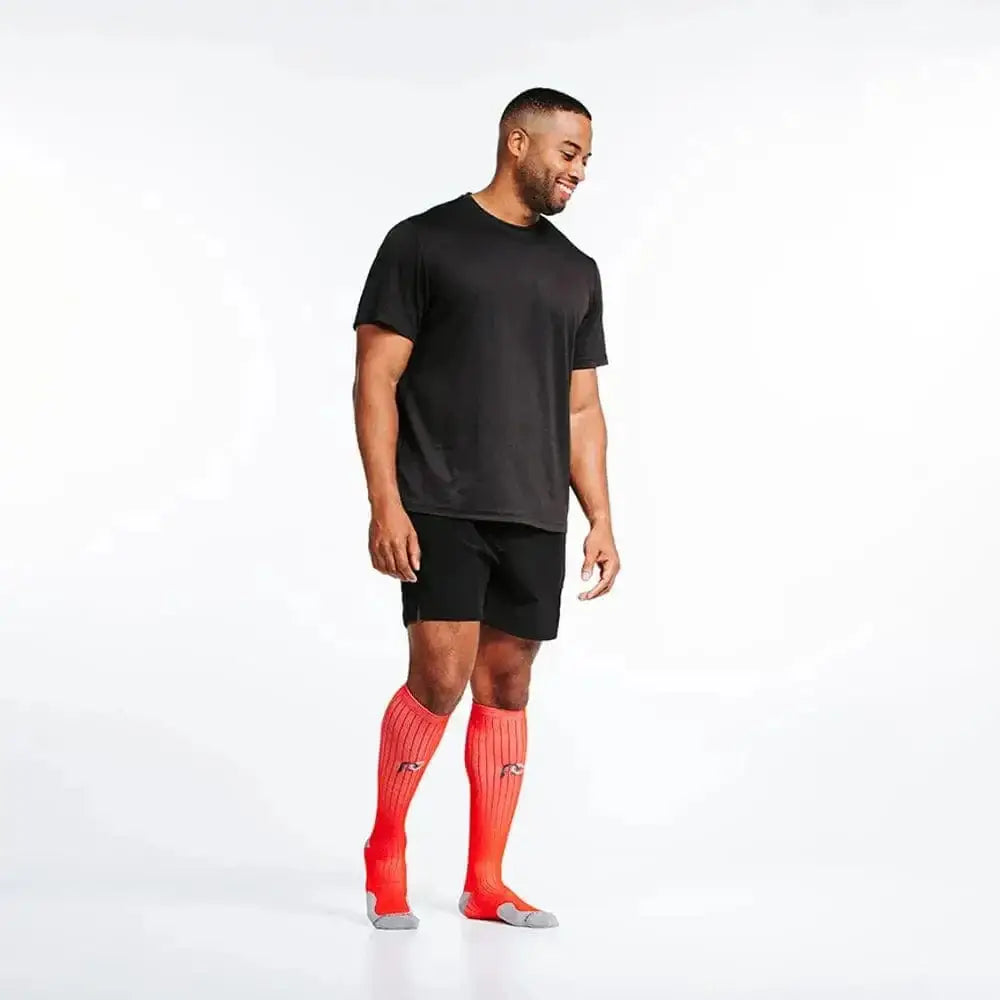 Athletic compression socks in red, styled with black shorts and t-shirt for marathon training