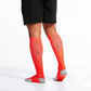 Bright coral-red knee-high compression socks with grey accents for marathon runners