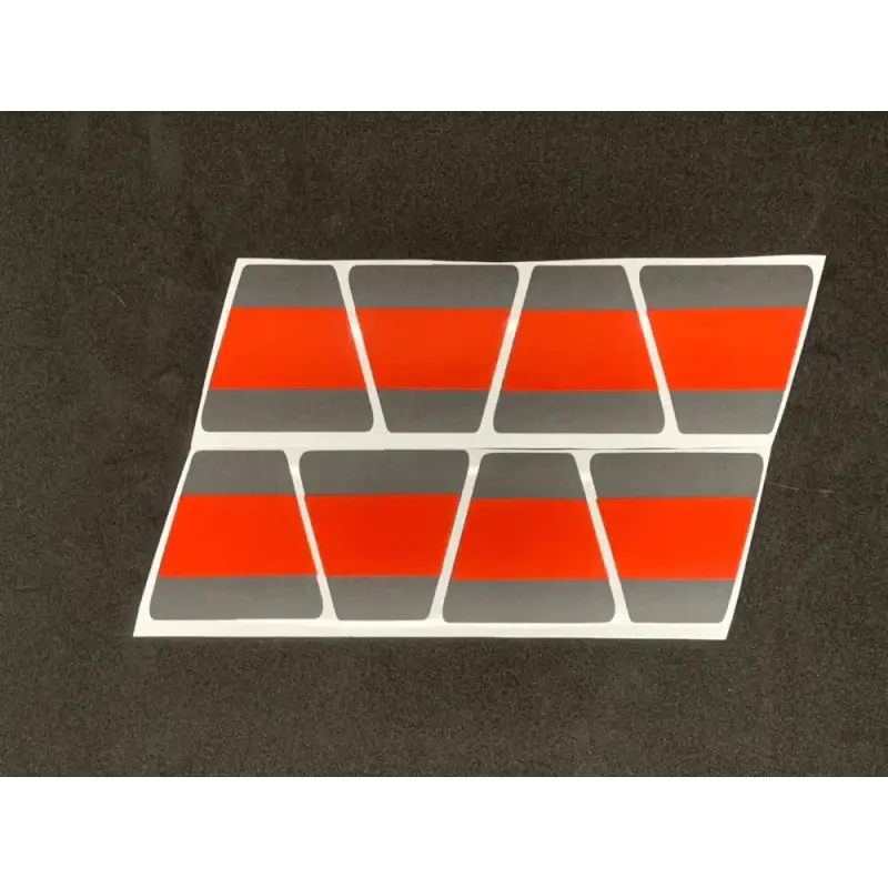 Eight trapezoid shapes with orange stripes, featured in the Matte Black with Matte Red Line Triple Stripe Reflective Helmet