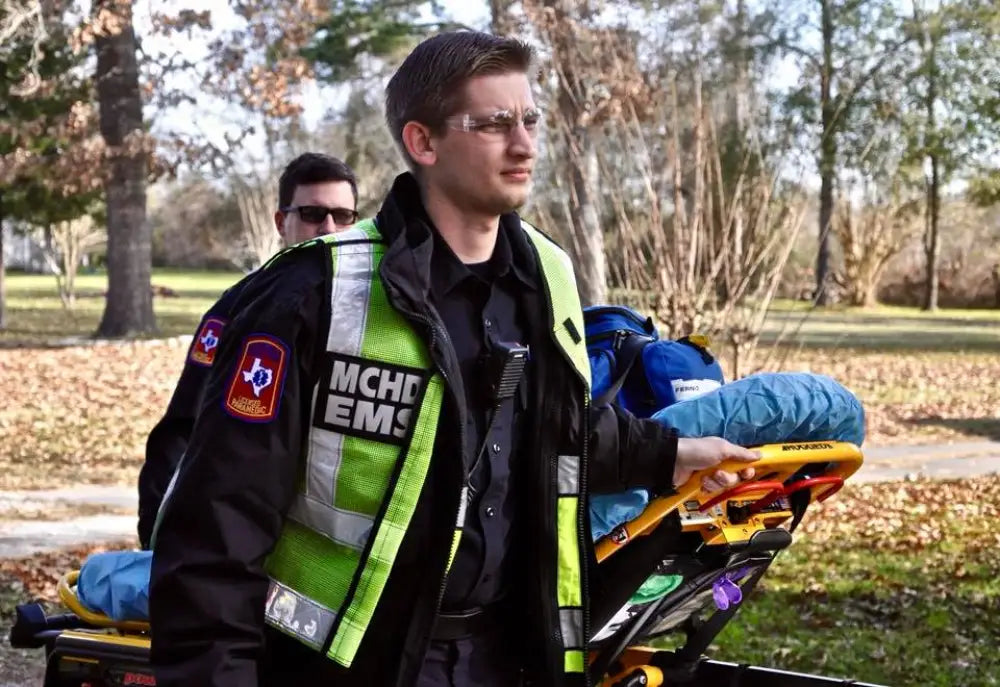 Emergency Medical Technician with MCHD ANSI II Adjustable Vest and stretcher in action