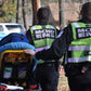 Two EMS workers in MCHD ANSI II Adjustable Vests transporting a patient on a stretcher