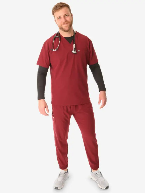 Medical professional in burgundy men’s double-pocket scrub top with stethoscope