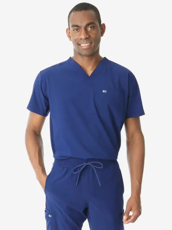 Medical professional in navy blue men’s double-pocket scrub top with v-neck design