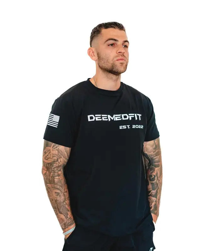 Black Men’s Gym Tee Compellence featuring DEEMEDFIT text and American flag patch