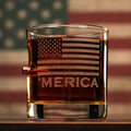 Glass tumbler with amber liquid, etched American flag, and Merica text for whiskey lovers
