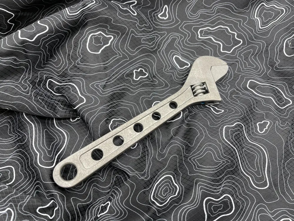 Metal titanium adjustable wrench with circular holes on handle for optimal grip and use