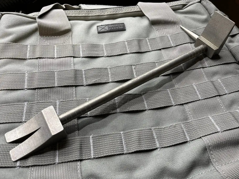 Metal pry bar tool with forked ends on gray tactical fabric for Hooligan Forced Entry