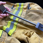 Metal tool over firefighter turnout gear showcasing the 12’’ XL Ti Hooligan Forced Entry Tool