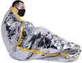 Metallic silver emergency space blanket retaining body heat around masked individual