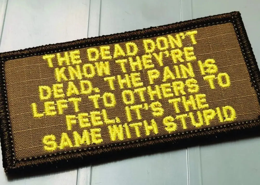 Military morale patch featuring yellow text on brown fabric saying THE DEAD DON’T KNOW THEY’RE DEAD - 2x4 Coyote w Yellow