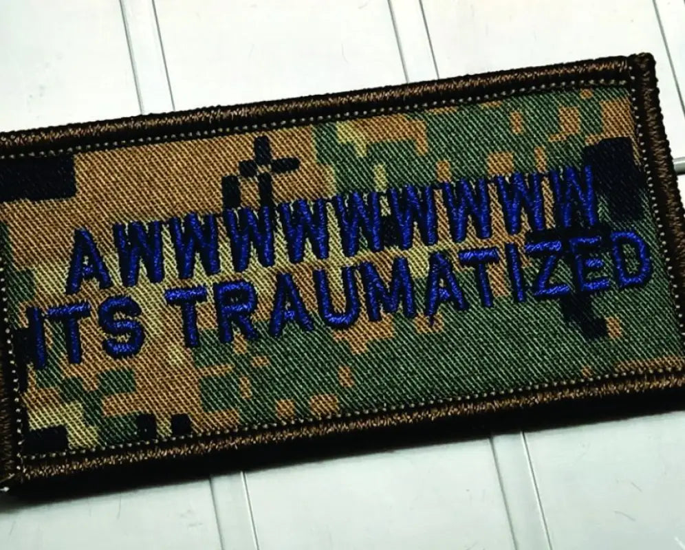 Military-style patch with blue text on camouflage, featuring Awwwwwwww It’s Traumatized - 2x4